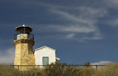 Eski bir deniz feneri Kıbrıs ve bulutlu mavi gökyüzü açık mimarisi