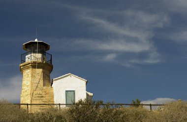 Eski bir deniz feneri Kıbrıs ve bulutlu mavi gökyüzü açık mimarisi