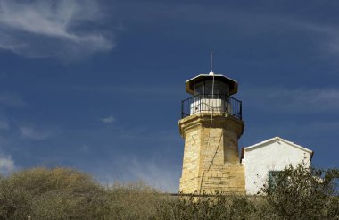 Eski bir deniz feneri Kıbrıs ve bulutlu mavi gökyüzü açık mimarisi