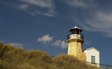Eski bir deniz feneri Kıbrıs ve bulutlu mavi gökyüzü açık mimarisi