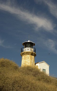 Eski bir deniz feneri Kıbrıs ve bulutlu mavi gökyüzü açık mimarisi