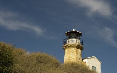 Eski bir deniz feneri Kıbrıs ve bulutlu mavi gökyüzü açık mimarisi