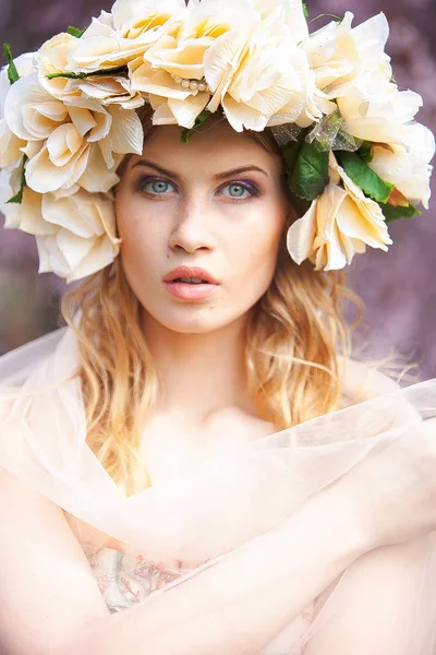 Bella donna bionda con corona di fiori in testa. Bellezza ragazza con acconciatura fiori. Ragazza in una foresta primaverile. Foto di moda — Foto Stock