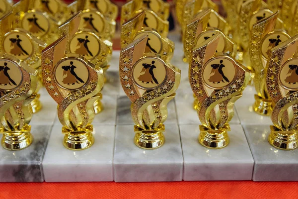 Gold medals and cups for the children of dancers are on the table closeup