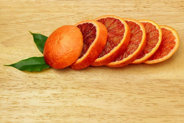 Red Orange Grapefruit Lies Wooden Board Cut Slices Green Leaves — Stock Photo, Image