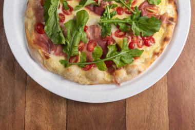 Kahverengi ahşap masada pizza.