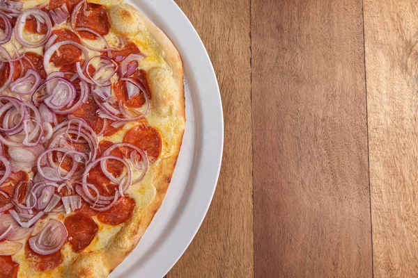 Pizza na mesa de madeira marrom — Fotografia de Stock