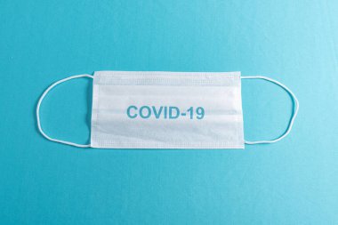 Minimalist mavi arkaplan üzerinde cerrahi maske