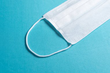 Minimalist mavi arkaplan üzerinde cerrahi maske