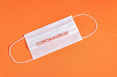 Minimalist turuncu arka plan üzerinde cerrahi maske