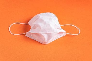 Minimalist turuncu arka plan üzerinde cerrahi maske
