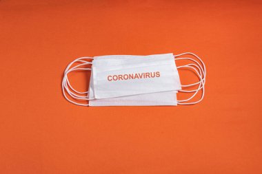 Minimalist turuncu arka plan üzerinde cerrahi maske