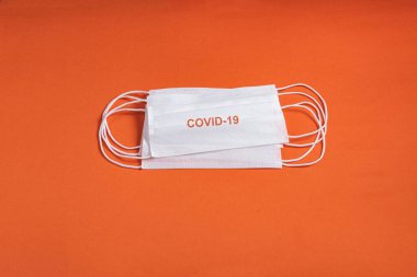 Minimalist turuncu arka plan üzerinde cerrahi maske
