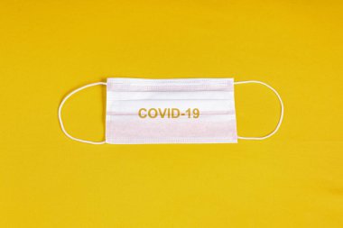 Minimalist turuncu arka plan üzerinde cerrahi maske