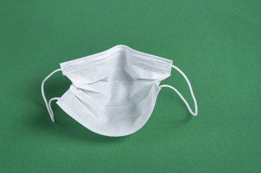 Minimalist yeşil arkaplan üzerinde cerrahi maske