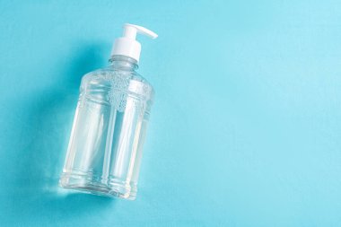 Açık mavi zemin üzerinde alkol jeli olan konteynır