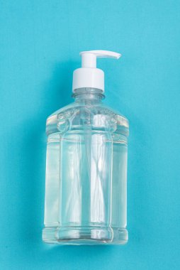 Açık mavi zemin üzerinde alkol jeli olan konteynır
