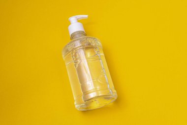 Turuncu arka planda alkol jeli olan konteyner.