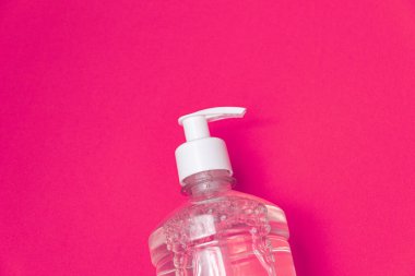 Turuncu arka planda alkol jeli olan konteyner.