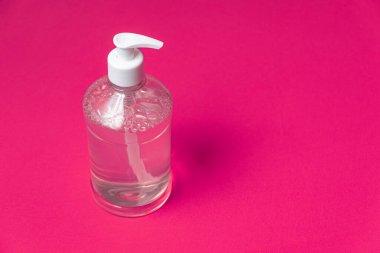 Turuncu arka planda alkol jeli olan konteyner.