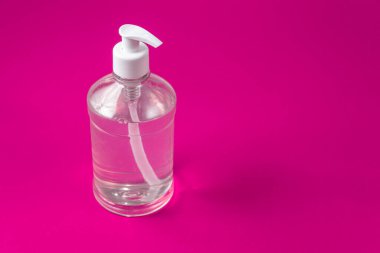 Kırmızı arka planda alkol jeli olan konteyner.