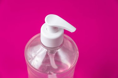 Kırmızı arka planda alkol jeli olan konteyner.