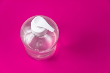 Kırmızı arka planda alkol jeli olan konteyner.