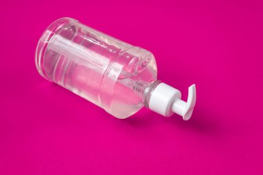 Kırmızı arka planda alkol jeli olan konteyner.