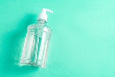 Açık mavi zemin üzerinde alkol jeli olan konteynır