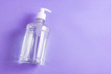 Açık mavi zemin üzerinde alkol jeli olan konteynır