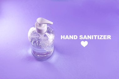 Açık mavi zemin üzerinde alkol jeli olan konteynır