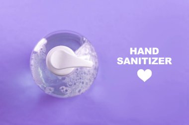 Açık mavi zemin üzerinde alkol jeli olan konteynır