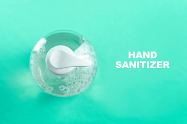 Açık mavi zemin üzerinde alkol jeli olan konteynır