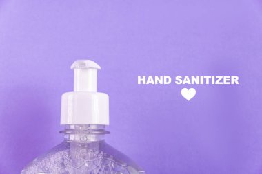 Açık mavi zemin üzerinde alkol jeli olan konteynır