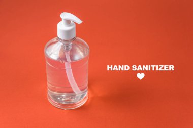 Kırmızı arka planda alkol jeli olan konteyner.