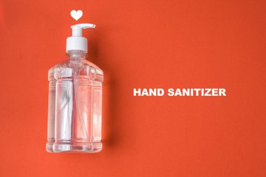 Kırmızı arka planda alkol jeli olan konteyner.