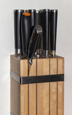 Tahtadan yapılmış bir bıçak bloğu, siyah ve farklı çelik bıçaklarla. 