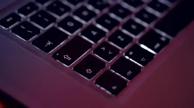 Karanlık bir odada dizüstü bilgisayar klavyesi. Ekrandaki kodlamanın kapatılması, insan elleri html kodluyor ve dizüstü bilgisayardaki programlama, web geliştirme, geliştirici.