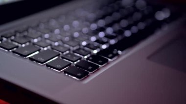 Karanlık bir odada dizüstü bilgisayar klavyesi. Ekrandaki kodlamanın kapatılması, insan elleri html kodluyor ve dizüstü bilgisayardaki programlama, web geliştirme, geliştirici.