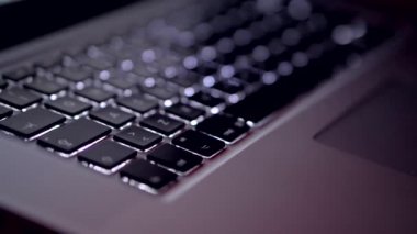 Karanlık bir odada dizüstü bilgisayar klavyesi. Ekrandaki kodlamanın kapatılması, insan elleri html kodluyor ve dizüstü bilgisayardaki programlama, web geliştirme, geliştirici.