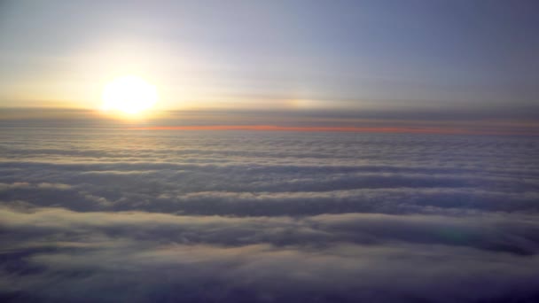 飛行機で飛んでいる 飛行機のイルミネーターからの日の出または日没 飛行機の翼は綿雲の中を飛ぶ 飛行機の窓からの眺め 飛行機だ 飛行機で旅行する カラフルな空 — ストック動画