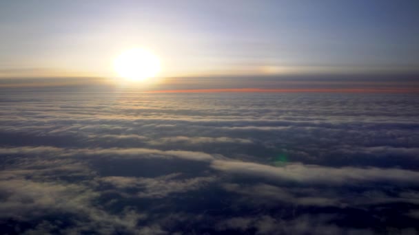 飛行機で飛んでいる 飛行機のイルミネーターからの日の出または日没 飛行機の翼は綿雲の中を飛ぶ 飛行機の窓からの眺め 飛行機だ 飛行機で旅行する カラフルな空 — ストック動画