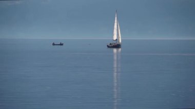 Como Gölü, İtalya. Gün batımında bir yelkenliyle seyahat etmek. Sinema panoraması. Yeşil dağların arka planında sevgilileriyle birlikte lüks bir yat gezisi. Romantik bir gezi. Beyaz yelken