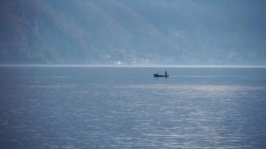 Como Gölü, İtalya. Balıkçılar gölde bir kayıkla yelken açarlar. Avrupa 'nın en büyük gölü. Yerel bir İtalyan restoranı için tatlı su gölünden taze balık. Doğa. Akşam vakti. Sakin su