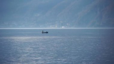 Como Gölü, İtalya. Balıkçılar gölde bir kayıkla yelken açarlar. Avrupa 'nın en büyük gölü. Yerel bir İtalyan restoranı için tatlı su gölünden taze balık. Doğa. Akşam vakti. Sakin su