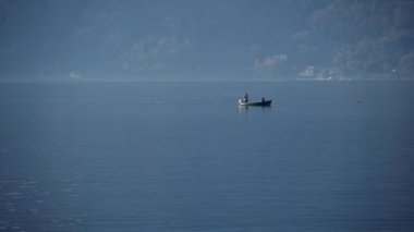 Como Gölü, İtalya. Balıkçılar gölde bir kayıkla yelken açarlar. Avrupa 'nın en büyük gölü. Yerel bir İtalyan restoranı için tatlı su gölünden taze balık. Doğa. Akşam vakti. Sakin su