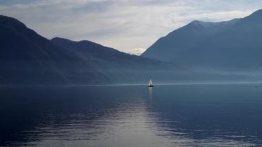 Como Gölü, İtalya. Gün batımında bir yelkenliyle seyahat etmek. Sinema panoraması. Yeşil dağların arka planında sevgilileriyle birlikte lüks bir yat gezisi. Romantik bir gezi. Beyaz yelken