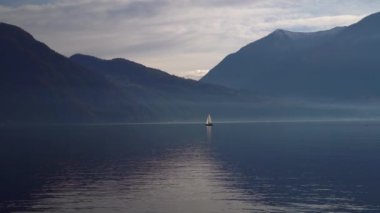 Como Gölü, İtalya. Gün batımında bir yelkenliyle seyahat etmek. Sinema panoraması. Yeşil dağların arka planında sevgilileriyle birlikte lüks bir yat gezisi. Romantik bir gezi. Beyaz yelken