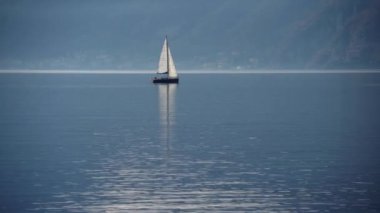 Como Gölü, İtalya. Gün batımında bir yelkenliyle seyahat etmek. Sinema panoraması. Yeşil dağların arka planında sevgilileriyle birlikte lüks bir yat gezisi. Romantik bir gezi. Beyaz yelken