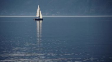 Como Gölü, İtalya. Gün batımında bir yelkenliyle seyahat etmek. Sinema panoraması. Yeşil dağların arka planında sevgilileriyle birlikte lüks bir yat gezisi. Romantik bir gezi. Beyaz yelken